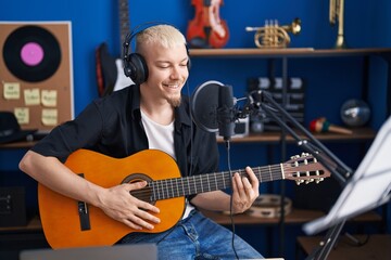 Young caucasian man musician singing song playing classical guitar at music studio