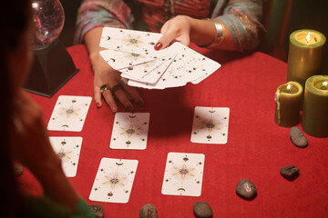 Hands of seer asking woman to choose cards from spread