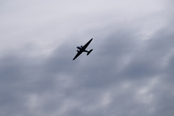 Fototapeta na wymiar An old propeller passenger airplane flying against a cloudy morning sky.