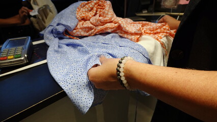 A woman buys clothes at the checkout. Payment terminal. Blue Dress. Shopping Conception