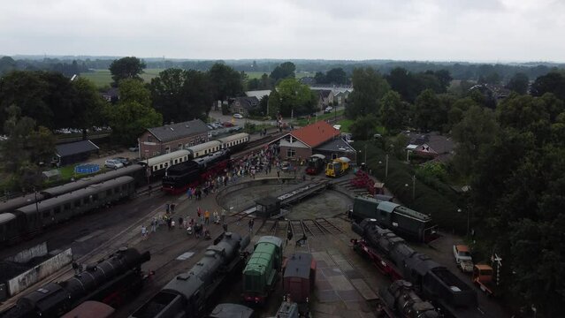 Beekbergen, the Netherlands - August 6th, 2023: Ascending drone footage of people lining up to see a steam locomotive on the local marshalling yard before it leaves on a trip to nearby Dieren.