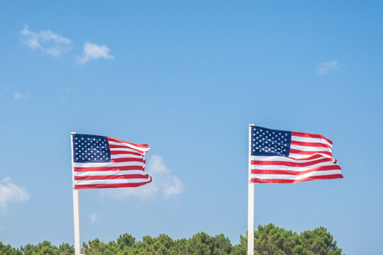 American flags waving in the wind against blue sky