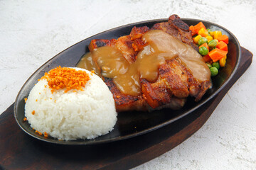 Freshly cooked sizzling pork belly served with mushroom gravy and rice
