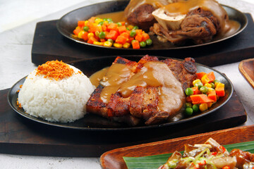 Freshly cooked sizzling pork belly served with mushroom gravy and rice