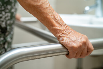 Asian elderly woman patient use toilet bathroom handle security in nursing hospital, healthy strong medical concept.