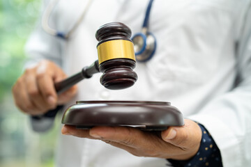 Doctor holding judge gavel, forensic medicine, medical law and crime justice concept.