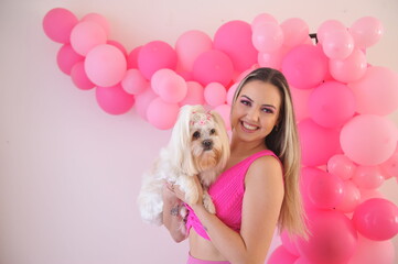 bela e jovem mulher vestida de rosa com sua cachorrinha de estimação fofa 