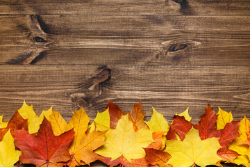 Autumn mood composition background. Frame made of autumn dried leaves on wooden background. Colorful, variegated foliage. Flat lay, top view, copy space.