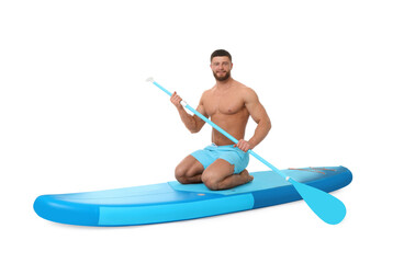 Handsome man with paddle on blue SUP board against white background