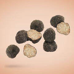 Cut and whole truffles falling on beige background