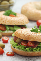Sesame bagels with tomatoes, ham and olives