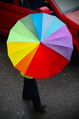 person holding a rainbow umbrella