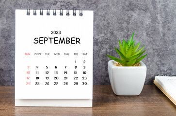 The September 2023 Monthly desk calendar for 2023 with diary on wooden table.