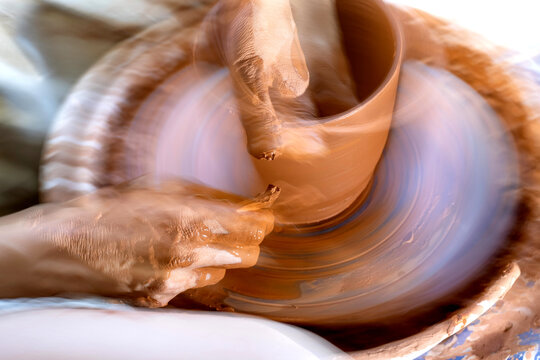 Dynamic image with blur of a pot being thrown on a potter's wheel emphasizing movement