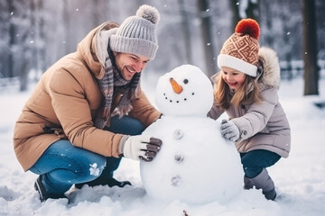 Family building a snowman in the winter park background  - obrazy, fototapety, plakaty