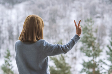 woman  standing on balcony and looking at snowy mountains.