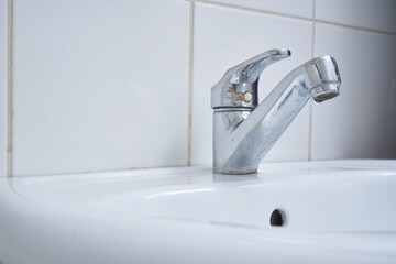 metallic wc faucet in a white wc
