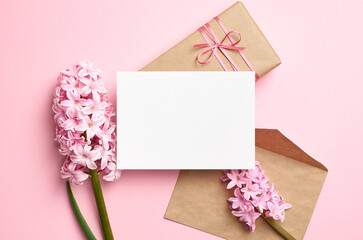 Blank greeting card mockup with envelope, gift box and flowers, white card mock up with copy space