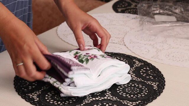 The woman makes a review of the purchase. He takes out terry towels from the package. Lays on the table. Close-up