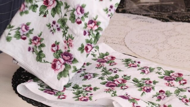 The woman makes a review of the purchase. Lays terry towels on the table. Close -up, from the side.