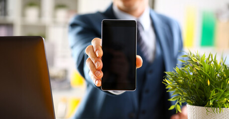 Male arm in suit show in camera phone display screen closeup. Read news mania send sms chat addict use electronic bank modern lifestyle job plan colleague share blog tweet web application search