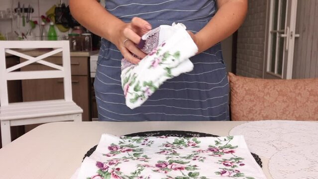 The woman makes a review of the purchase. Lays terry towels on the table. Middle Plan.