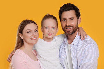 Portrait of happy family on orange background