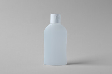 Bottle of cosmetic product on light grey background