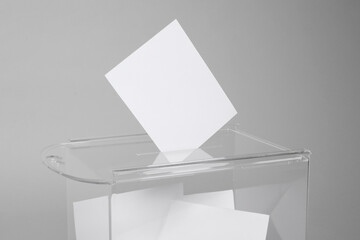 Ballot box with votes on light grey background. Election time