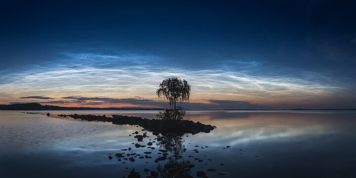 Noctilucent clouds on a summer night over the lake