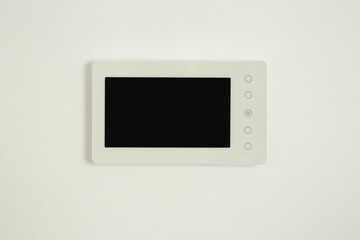 Modern video intercom hanging on white wall
