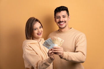 happy couple with brazil banknotes currency in all beige colors. finance, investment, offer, loan...