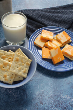 A snack of cheese and crackers with a glass of milk