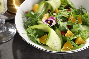 Delicious salad with cucumber and orange slices on gray table, closeup