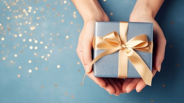 Un cadeau dans les mains d'une femme sur fond bleu