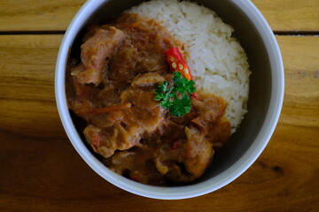 Simmered pork with tomato in white bowl