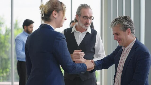 Caucasian man leader introducing woman manager to new team partner at seminar of company. Male leader introducing woman manager shaking hands welcoming newcomer