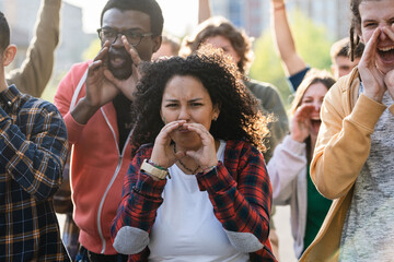 Young Activists Yelling During City Protest - A group of young activists passionately raising their voices during a protest in the city, advocating for rights and change.