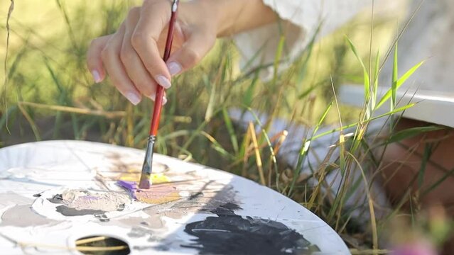 A woman artist paints a picture during sunset. Artist, art for sale, inspiration in nature