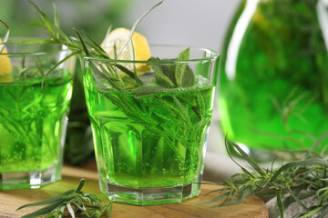 Refreshing tarragon drink with lemon slices on table, closeup