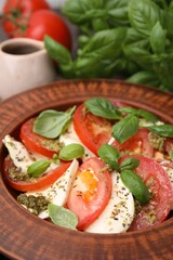 Plate of delicious Caprese salad with pesto sauce on table, closeup