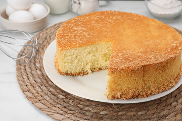 Tasty sponge cake on white table, closeup