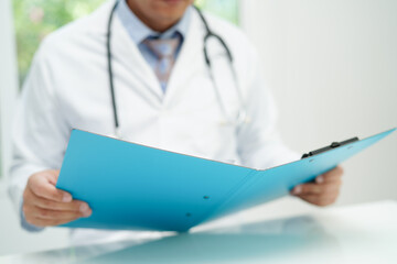 Asian man doctor study document to research method and technic for treating patients.