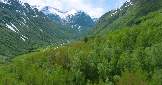 Aerial Drone View of Valley with River and Snow Capped Mountains (Norway)