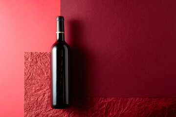 Bottle of red wine on a red background.