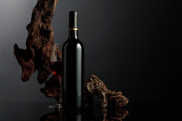 Red wine and old snag on a black background.