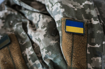 A banner of the Ukrainian flag on a military camouflage suit. Pixeled digital soldier's pixel...