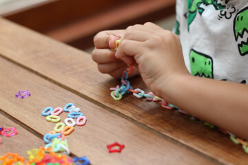 Obraz premium A little boy is playing with colorful plastic chain toy