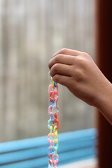 A little boy is playing with colorful plastic chain toy