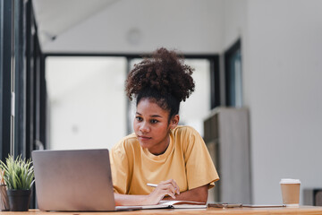African American businesswoman or accountant with afro hair using a calculator, graphs, and charts to analyze market data, balance sheets, accounts, and net profits.